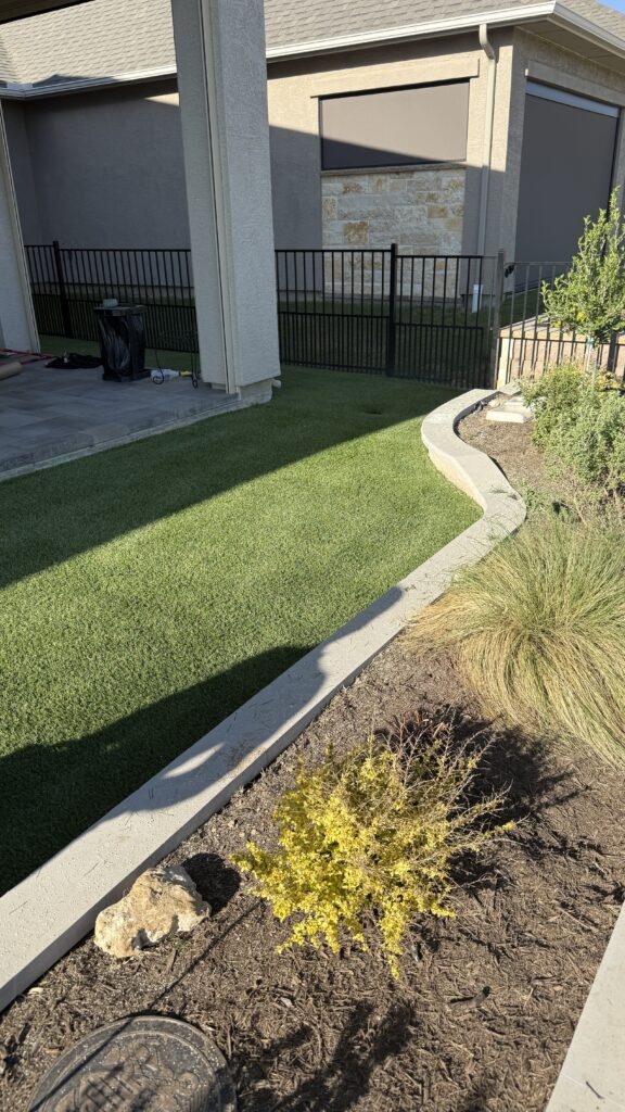 Backyard artificial turf installation with curved edging in DFW Texas
