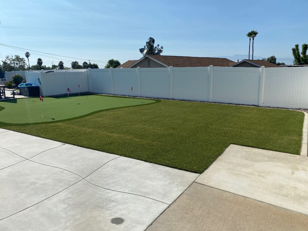Backyard putting green with surrounding turf lawn and landscaping - Green Forever Turf Texas