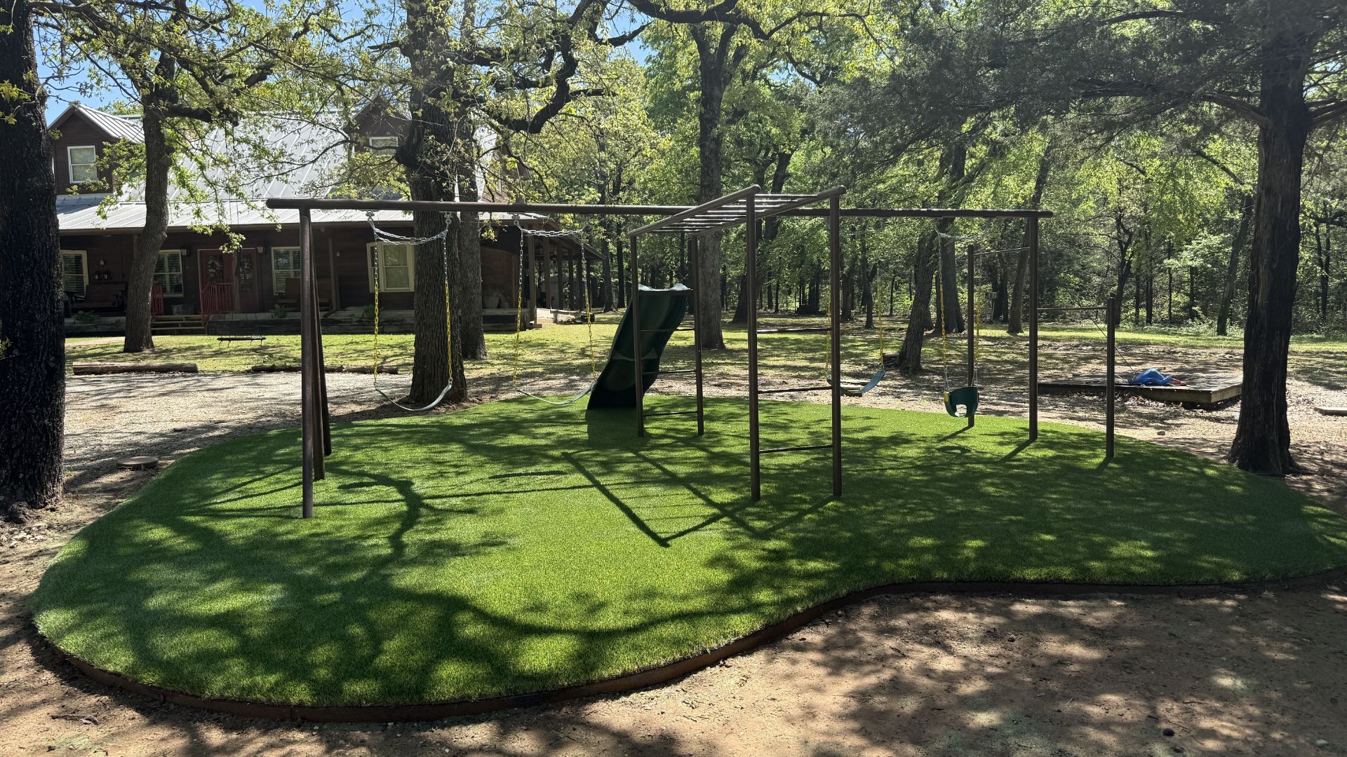 After: completed playground with turf, swing, and slide