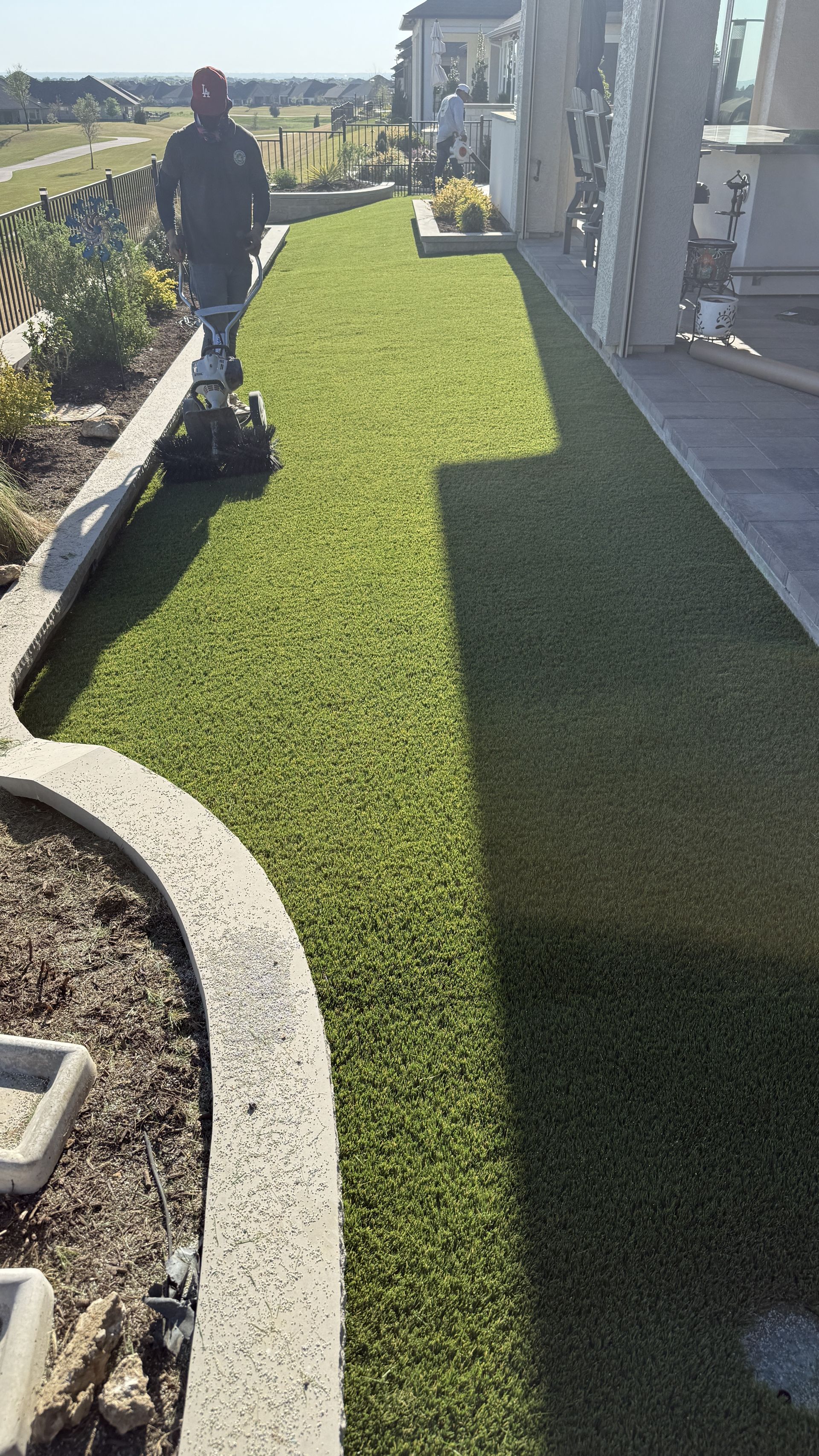 Green Forever Turf crew brooming artificial turf during installation