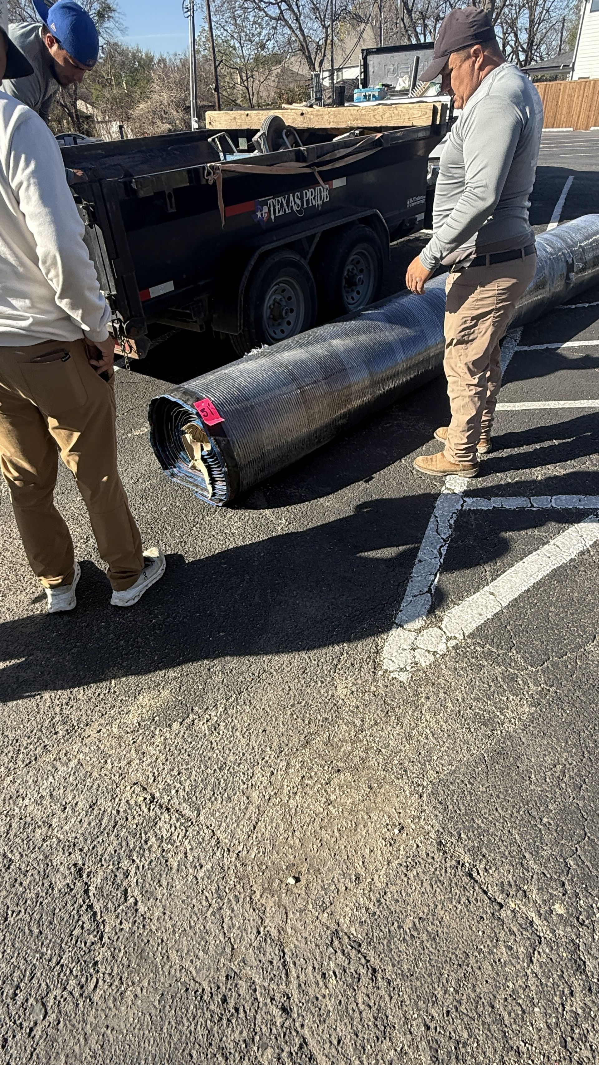 Green Forever Turf crew carrying a turf roll to a job site