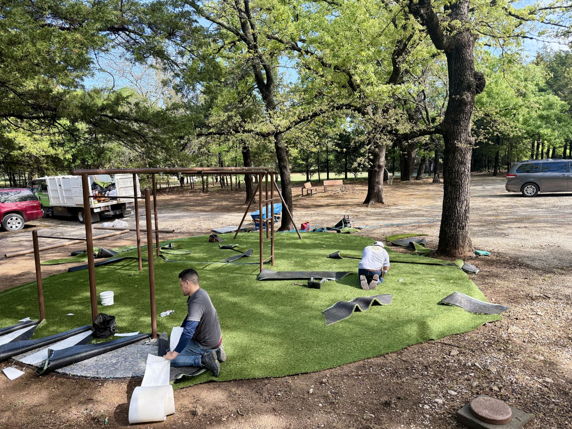Crew installing turf at a playground in the DFW area