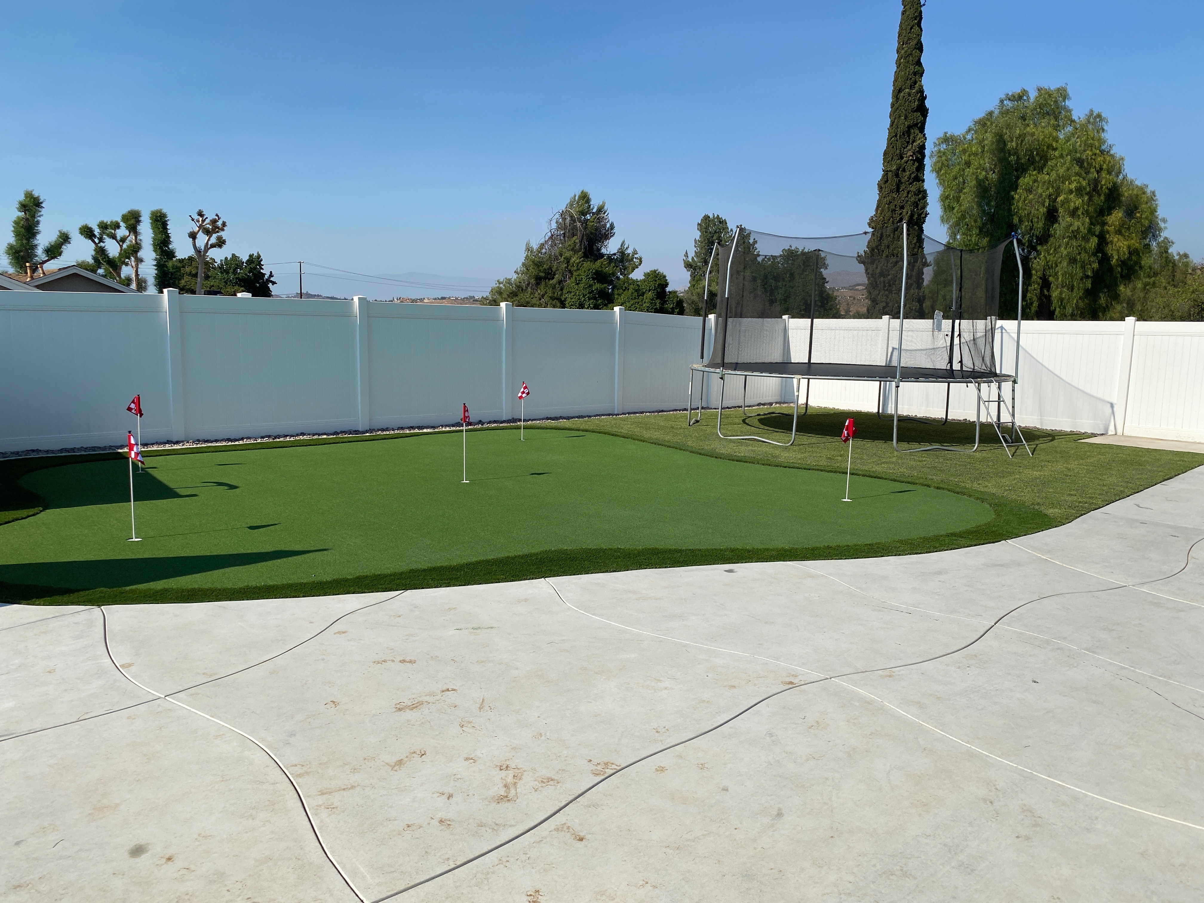 Putting green with family trampoline play area on artificial turf - Green Forever Turf Texas