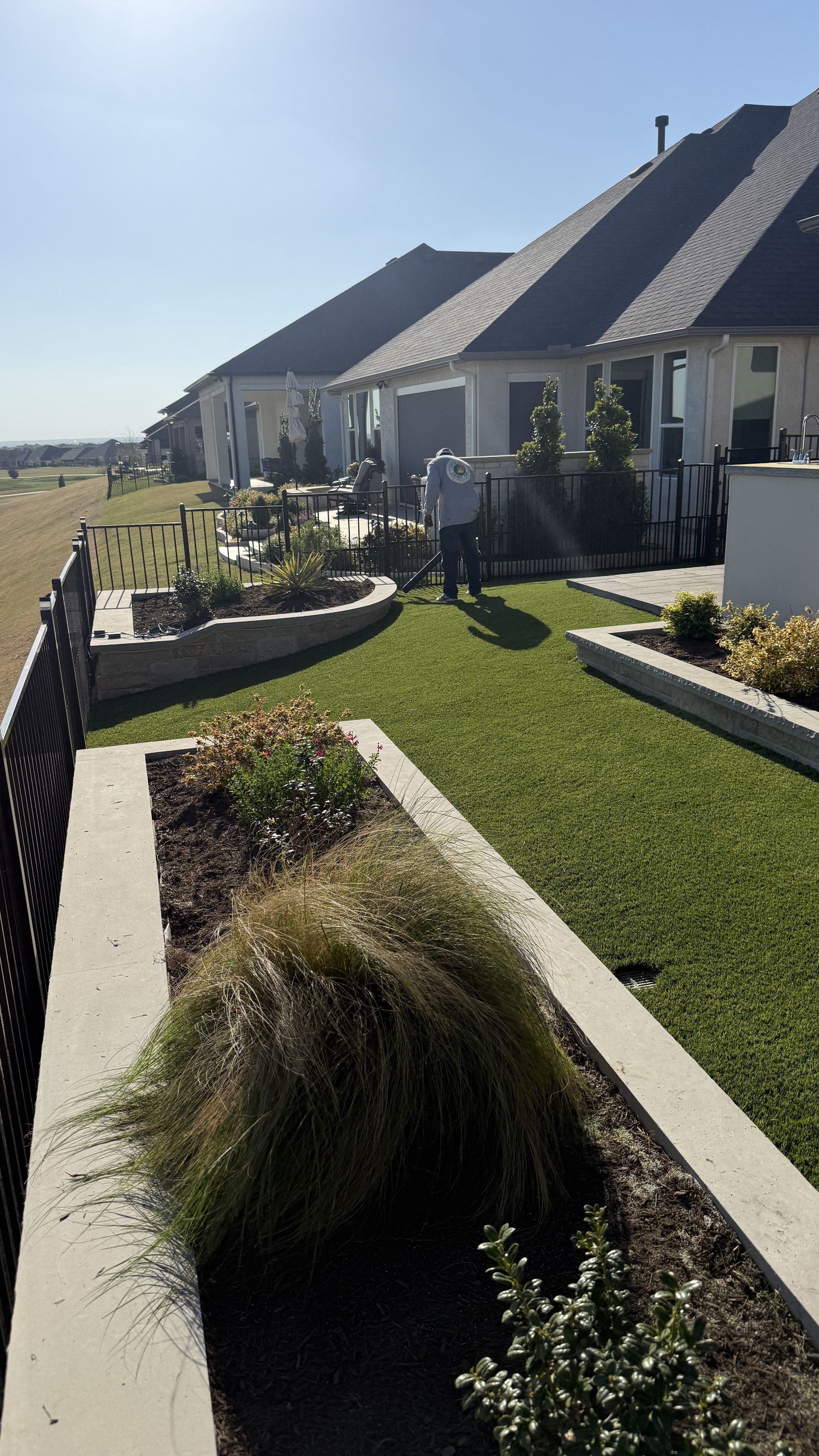Turf sideyard with curved planters in Grapevine home